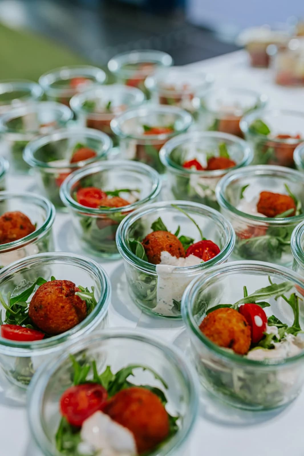 Vorspeisen im Weckglas mit Hackbällchen und Tomate, in Reihen auf der Buffettafel
